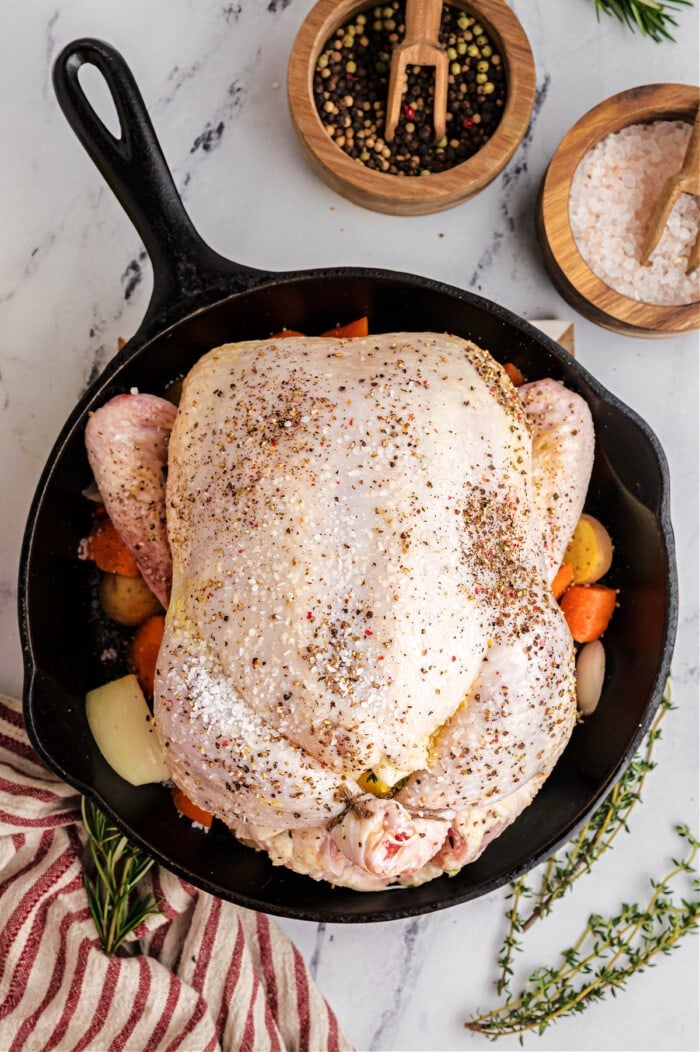 chicken with seasoning in cast iron skillet