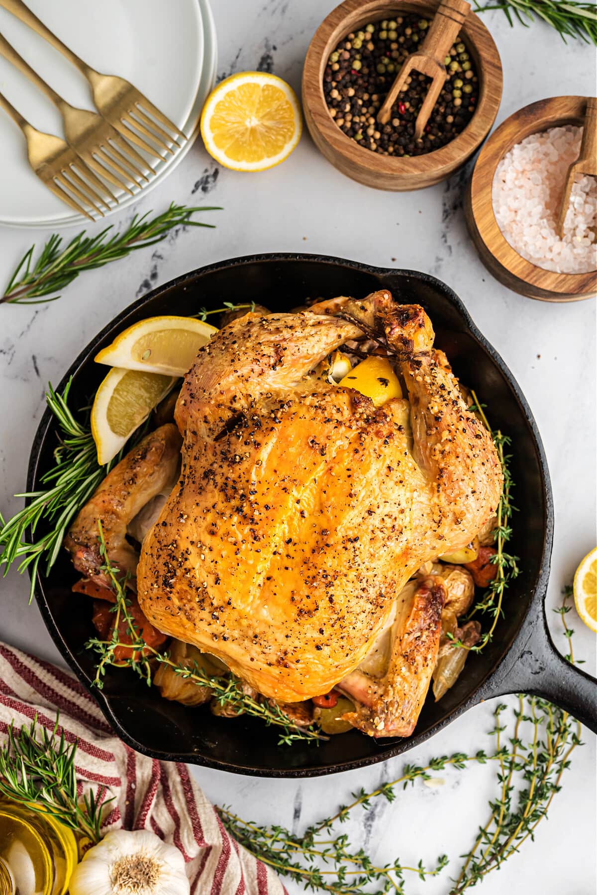 roasted chicken in cast iron skillet with lemons and herbs