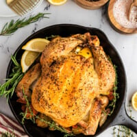 roasted chicken in cast iron skillet with lemons and herbs