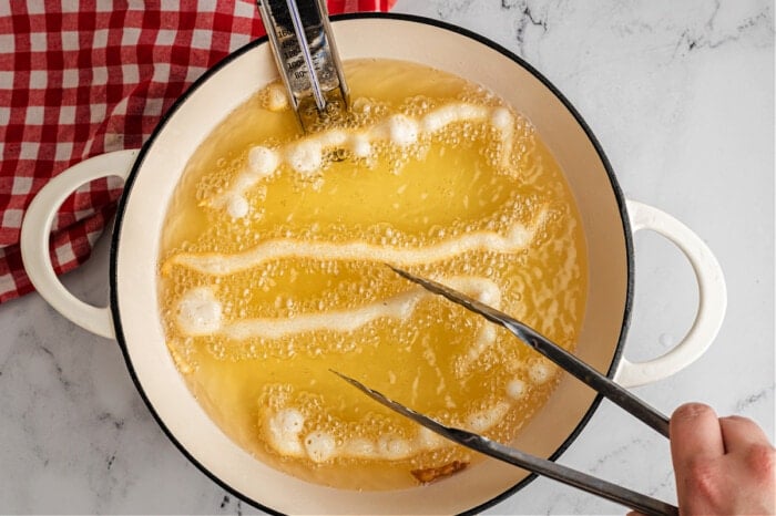 pancake batter in hot oil in pan