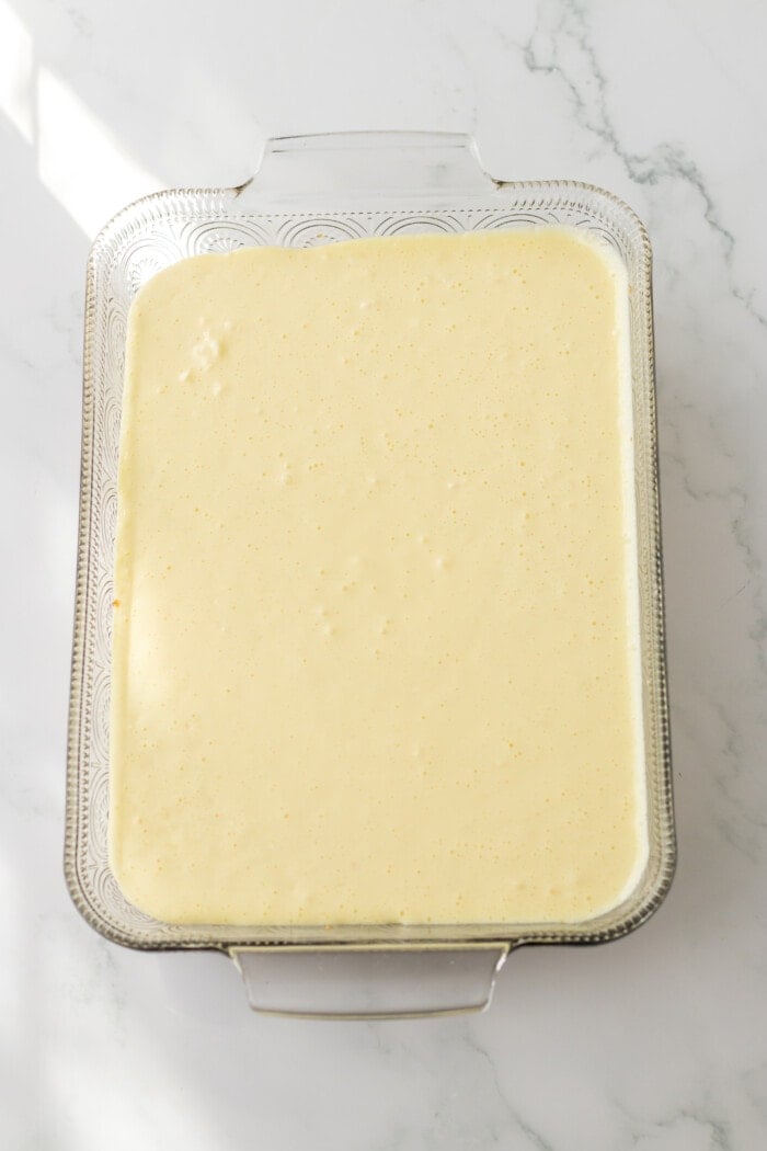 Adding the cheesecake layer into the pan for Pina Colada Lush
