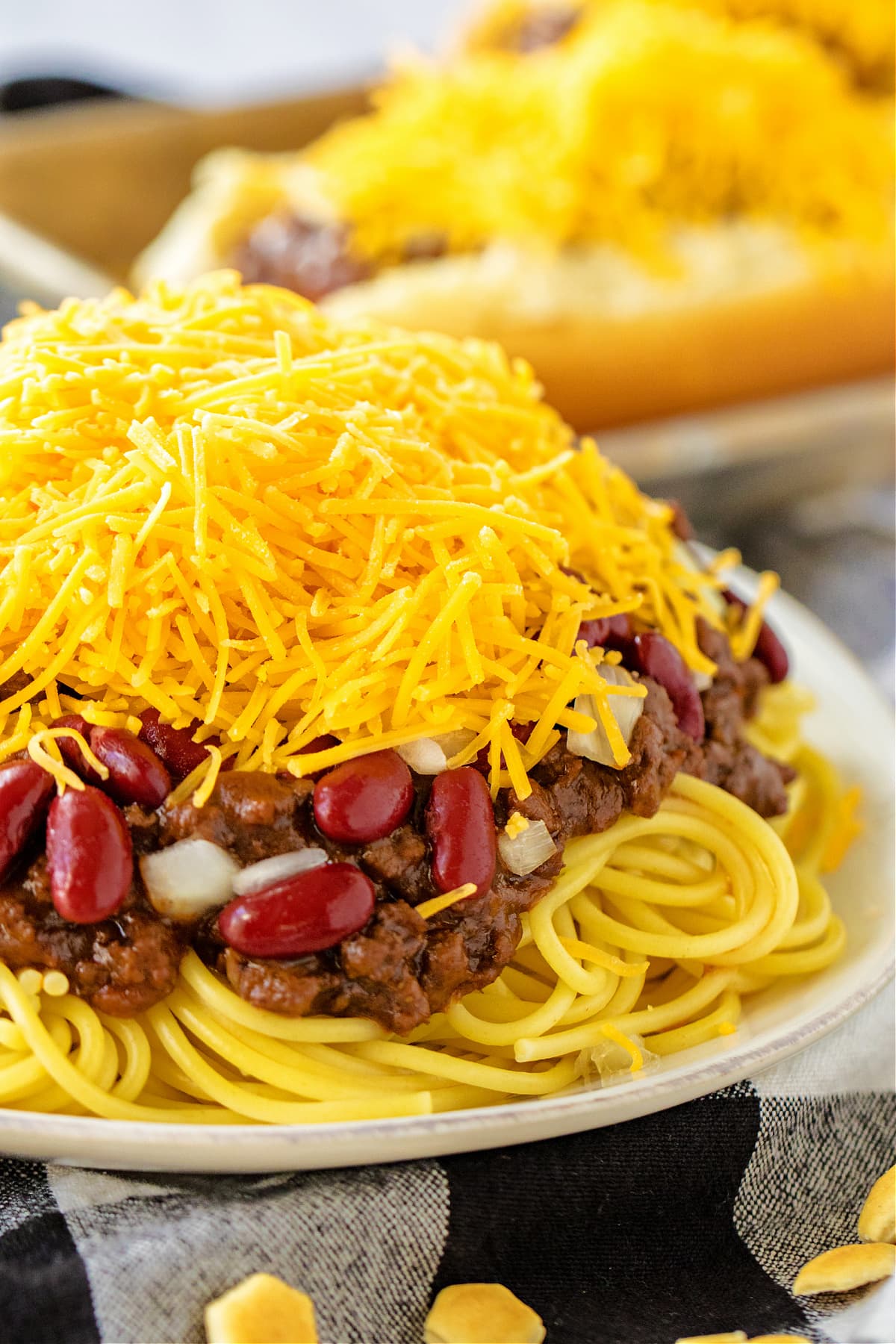 cincinnati chili on top of cooked spaghetti with beans and cheese