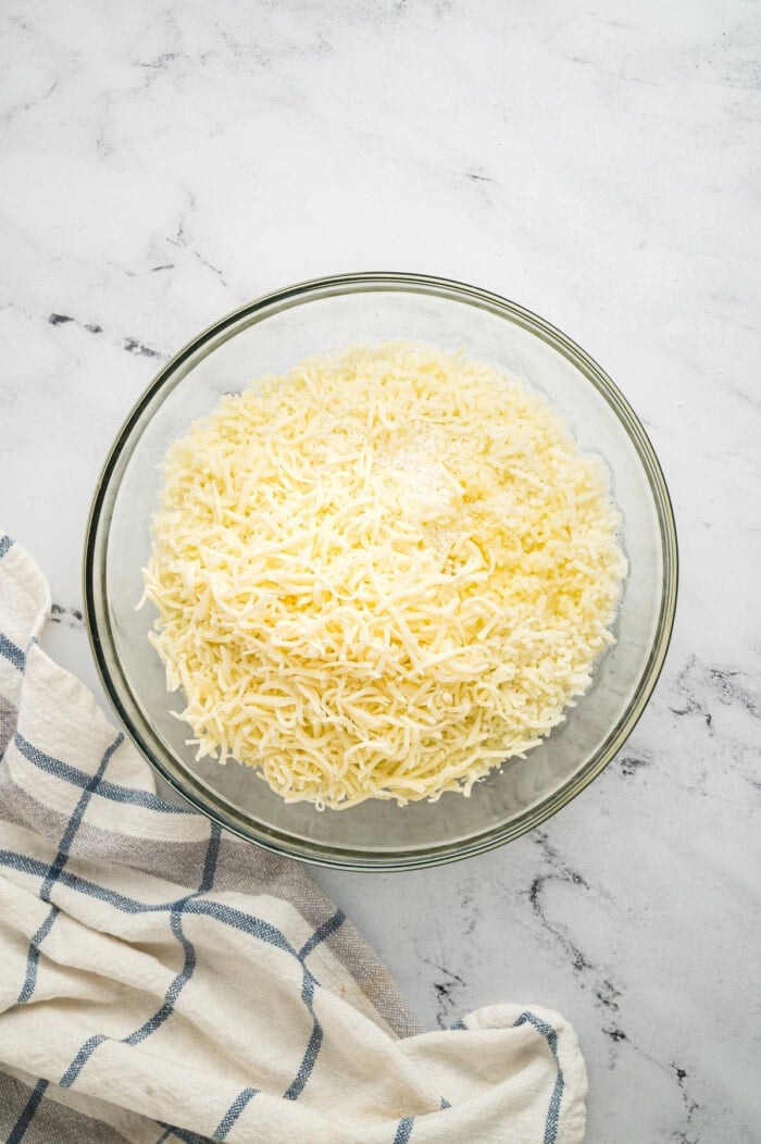 Shredded mozzarella and potatoes in a bowl