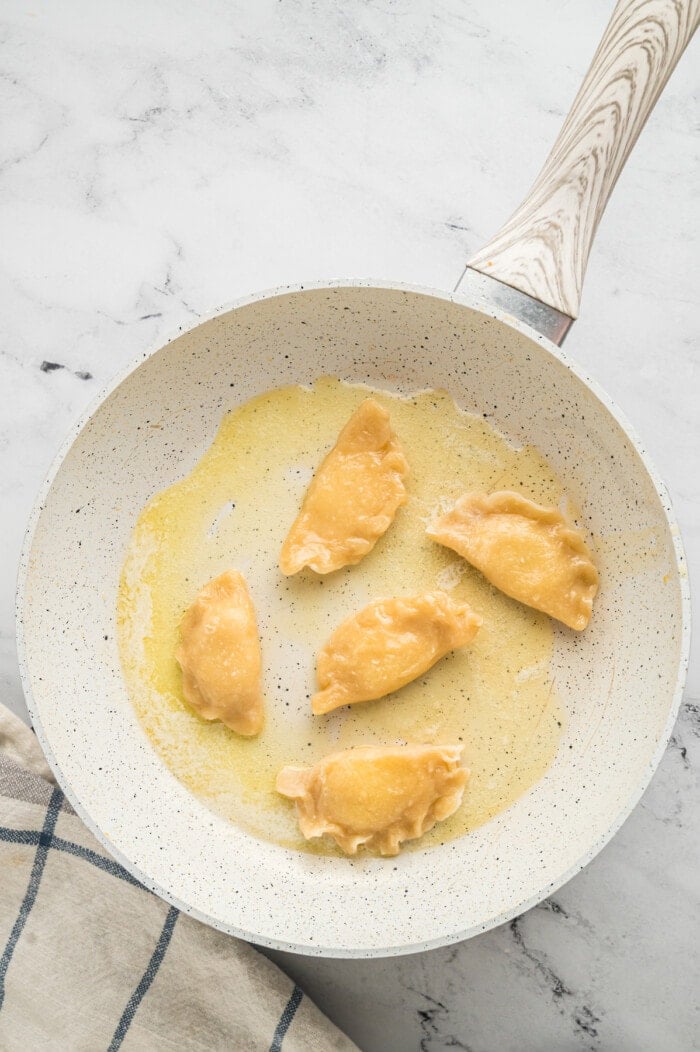 Pierogies in a pan with butter