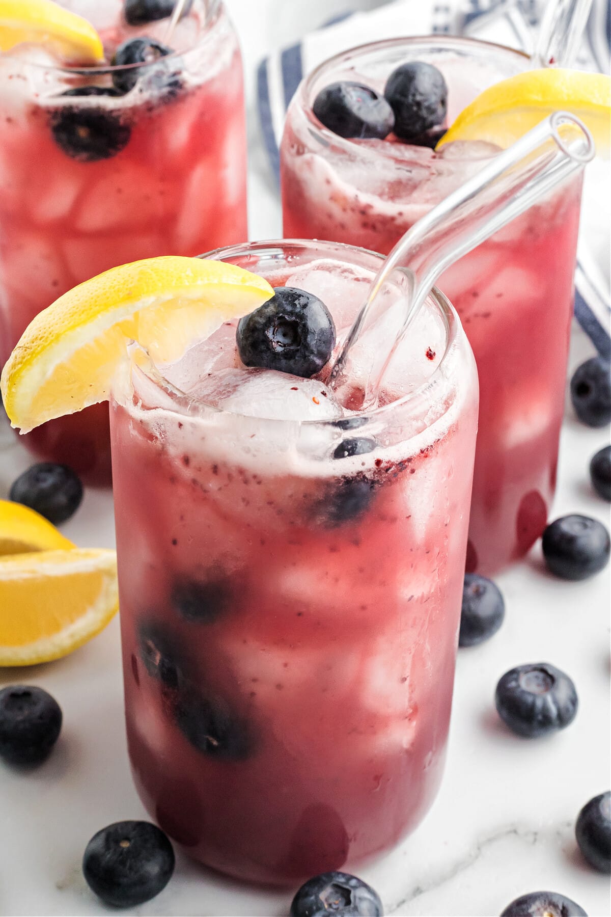 blueberry lemonade in glasses with clear straws