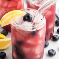 blueberry lemonade in glasses with clear straws