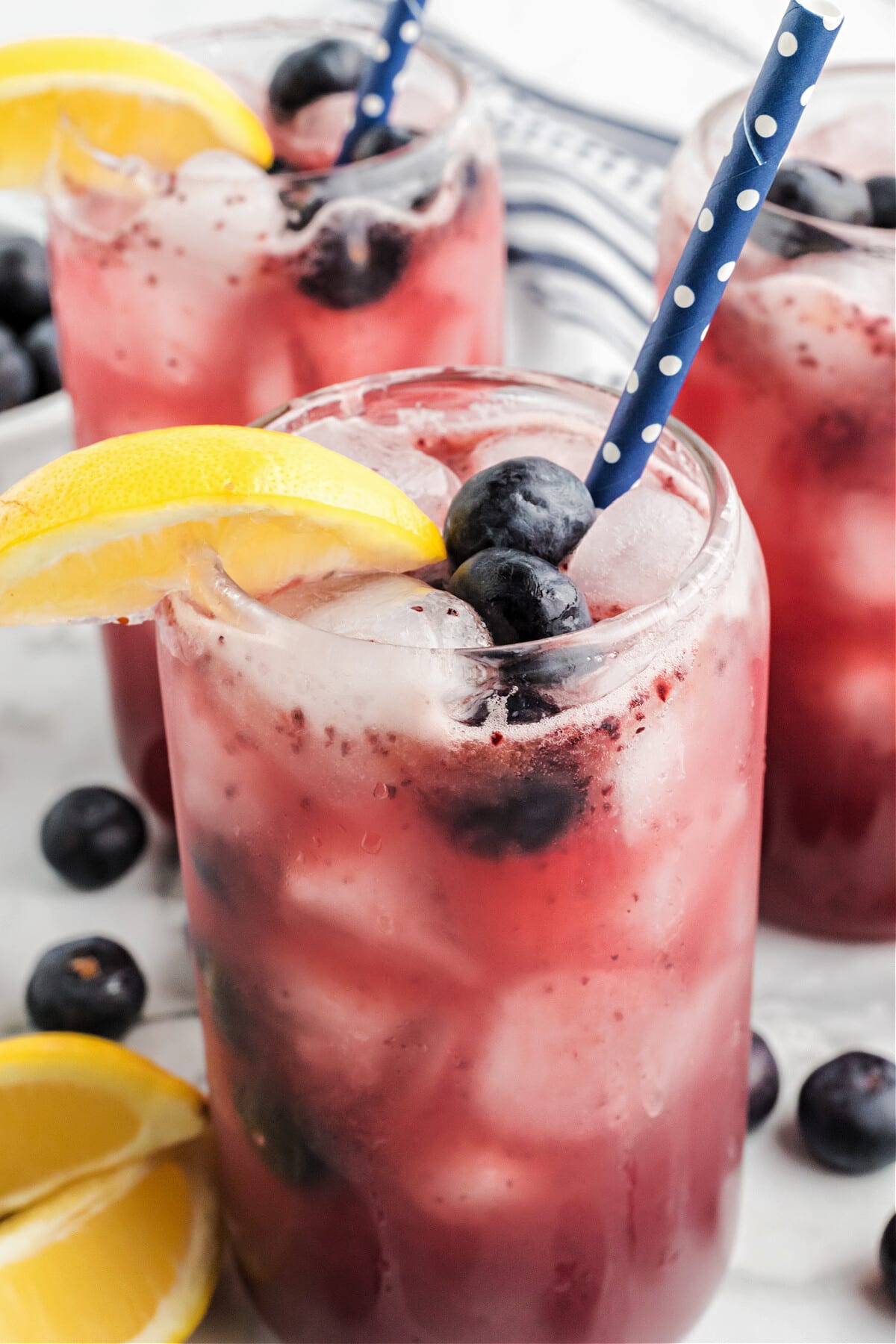 blueberry lemonade in glasses with blue straws