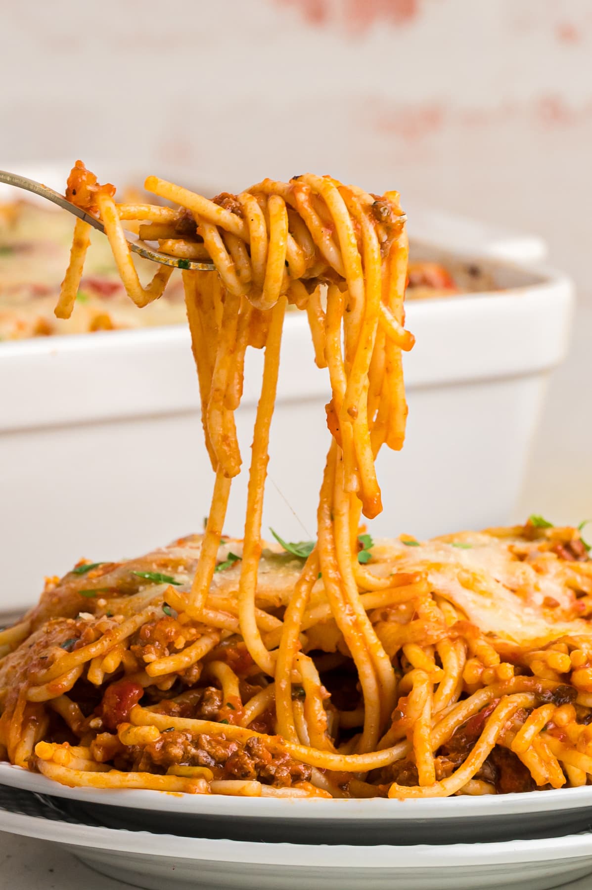 Spaghetti on a fork over a plate of spaghetti