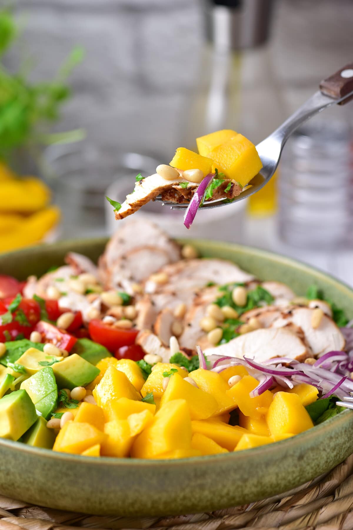 This Mango Chicken Salad is the perfect combination of sweet, savory, creamy, and crunchy in every bite. A fork lifting up some of the Mango Chicken Salad.