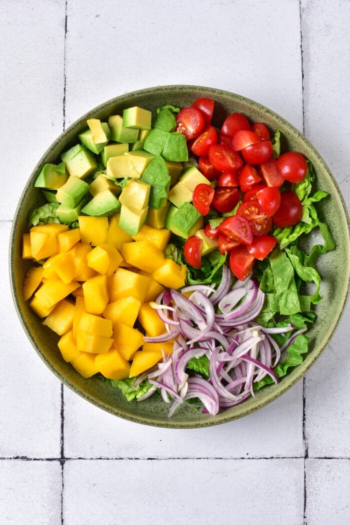 This Mango Chicken Salad is the perfect combination of sweet, savory, creamy, and crunchy in every bite. Adding the tomatoes and avocado to the Mango Chicken Salad.