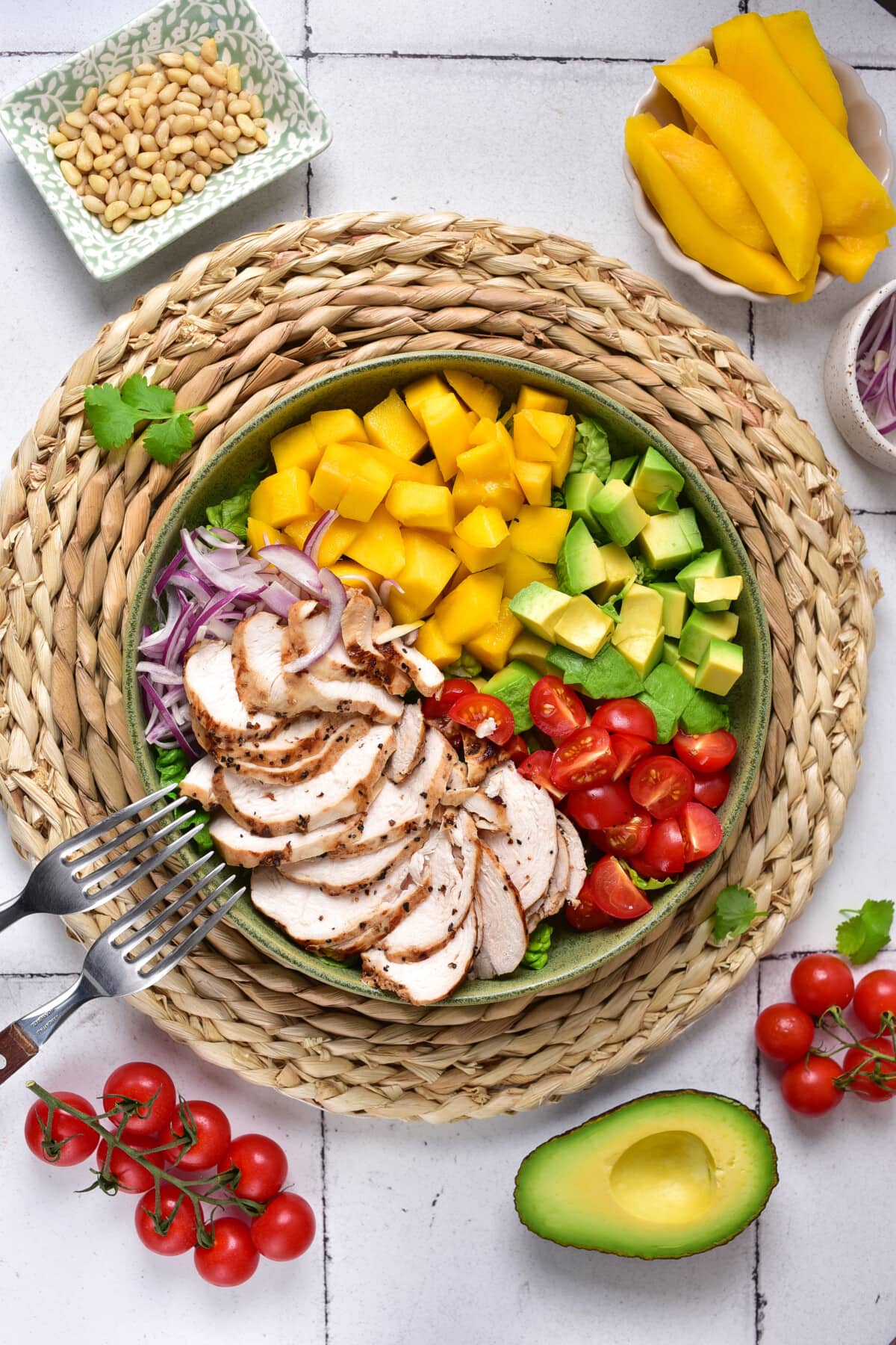 Mango Chicken Salad on a white table with additional ingredients.