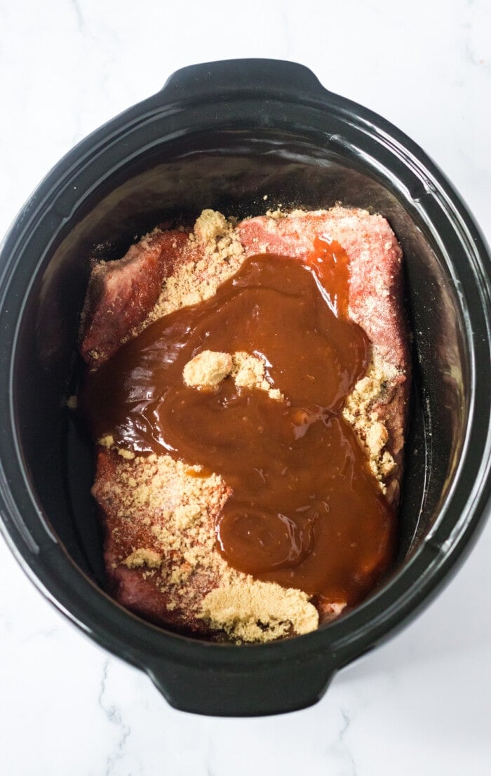 Brisket in the slow cooker topped with BBQ sauce