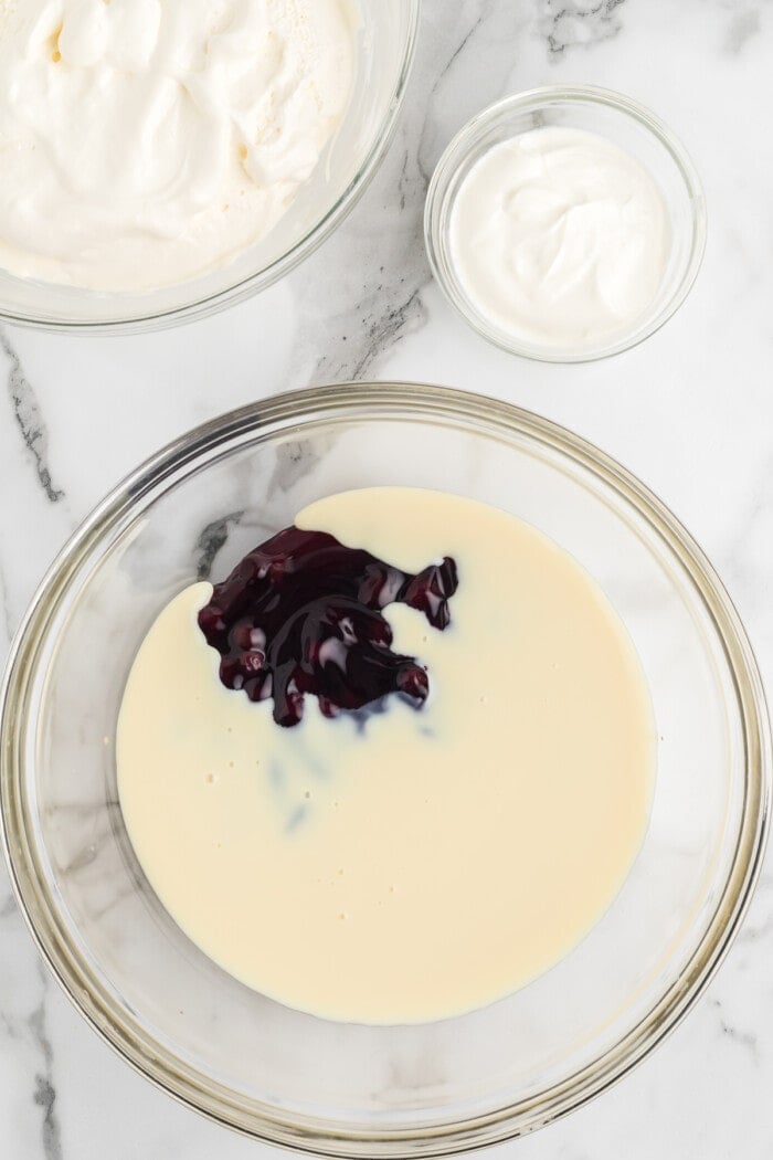 sweetened condensed milk and blueberry pie filling in glass bowl