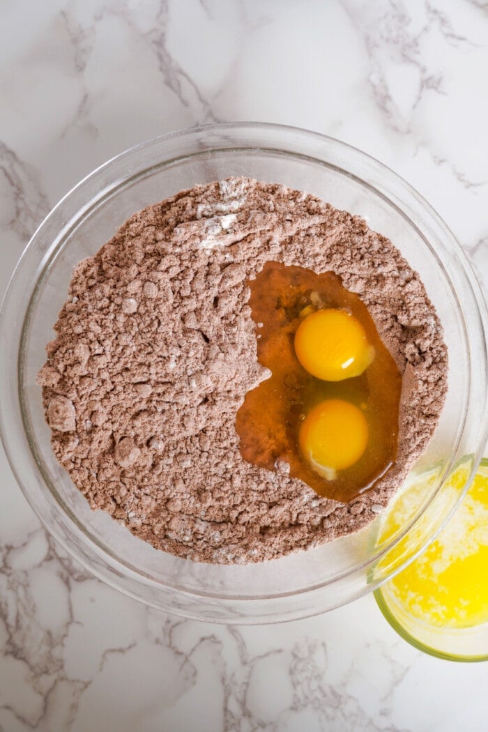 brownie mix in clear glass bowl with eggs