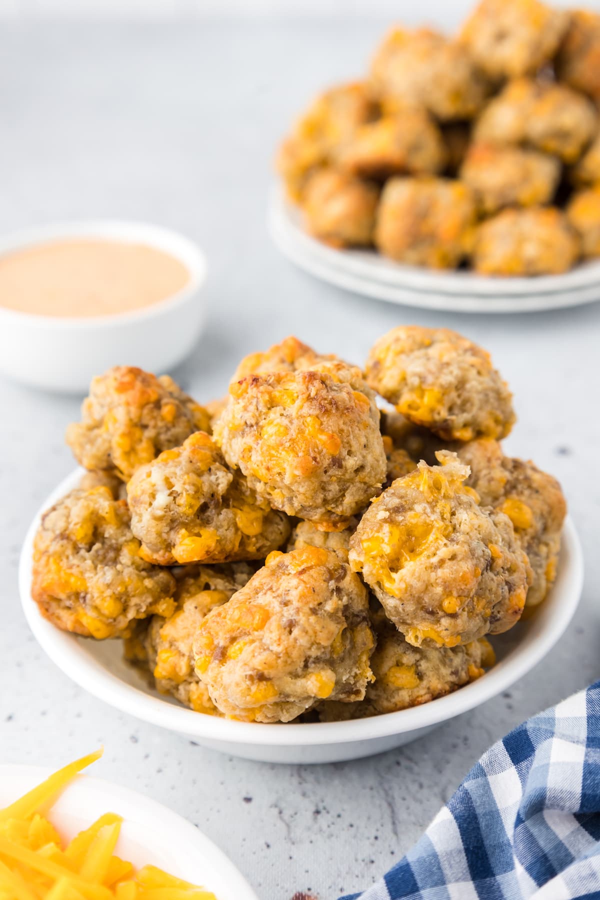sausage and cheese balls in white bowl with dipping sauce