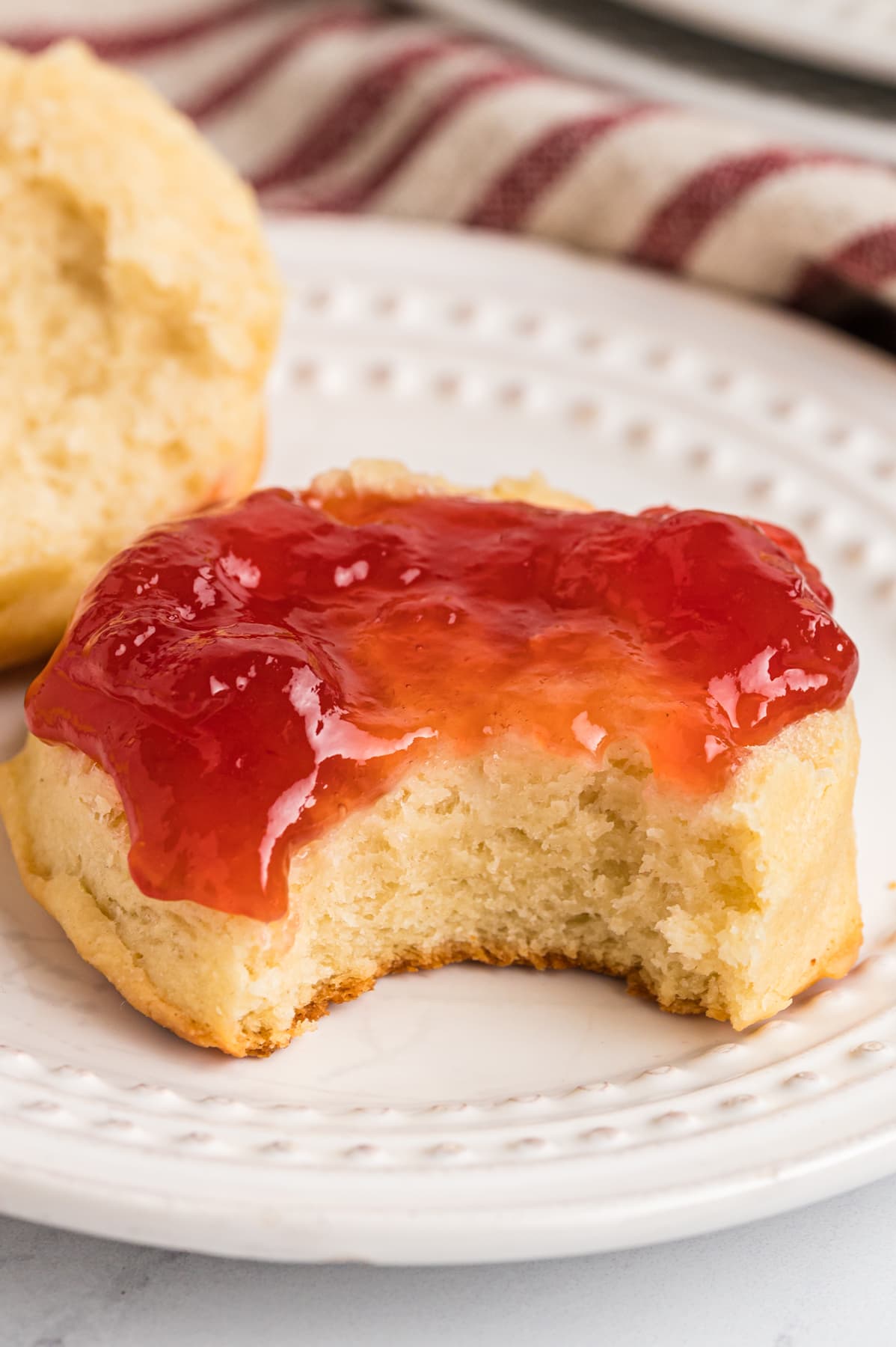 A biscuit with jelly and a bite missing