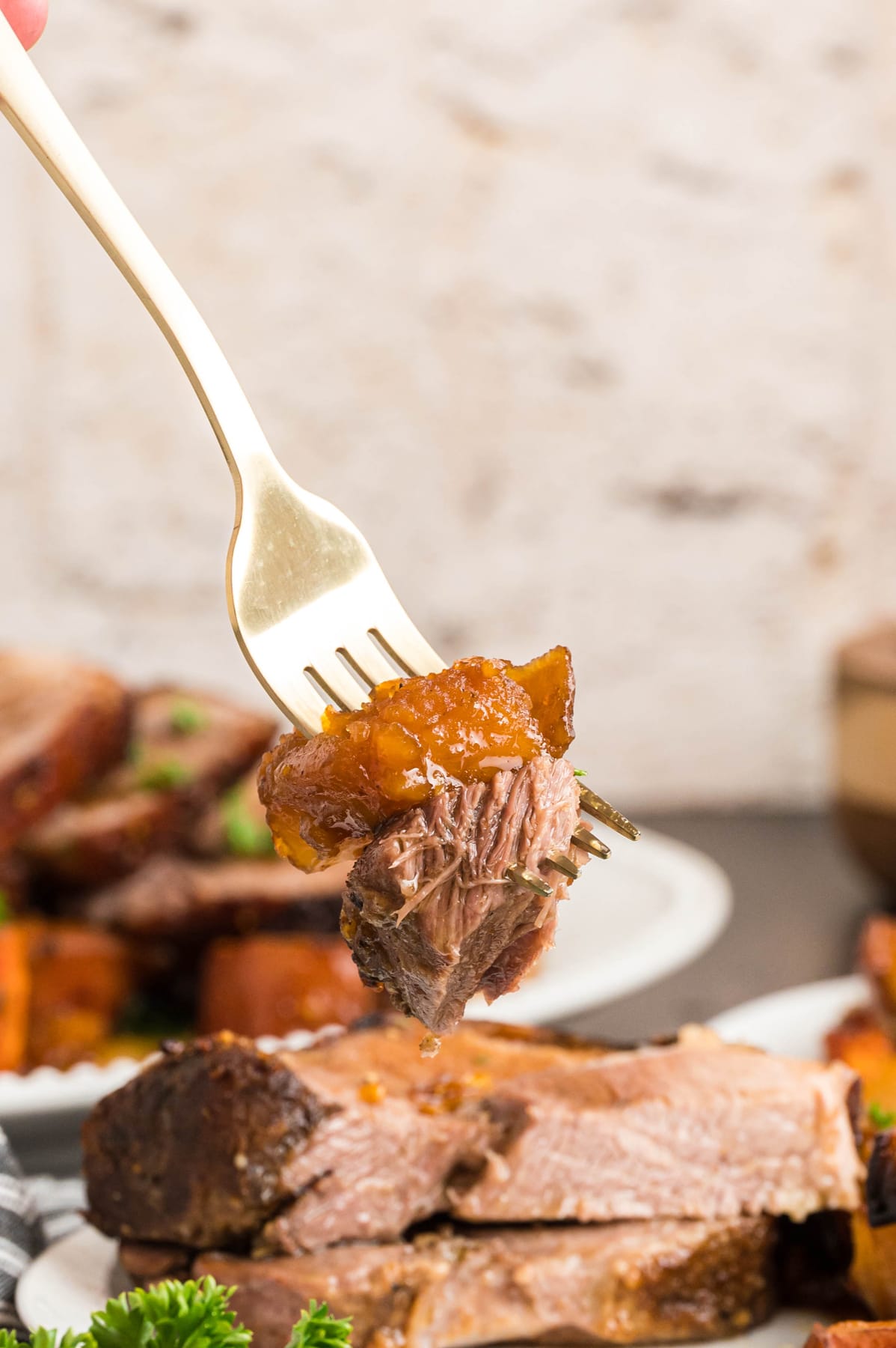 A bite of pork roast on a fork