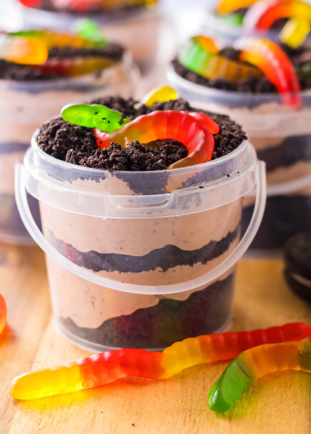 dirt pudding in a plastic bucket with gummy worms on top