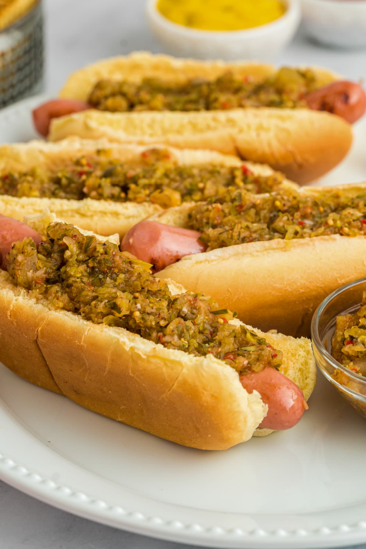 hot dogs on white platter with relish
