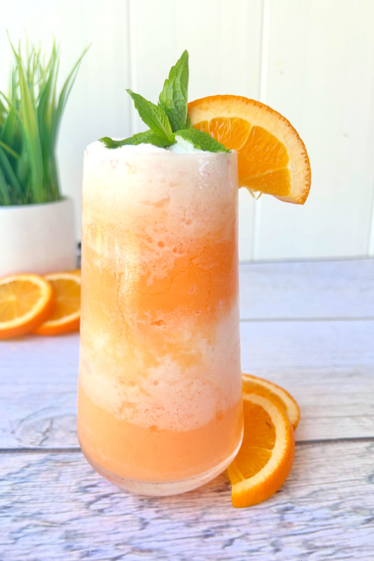 Orange Julius Cocktail with a wedge of orange on top.
