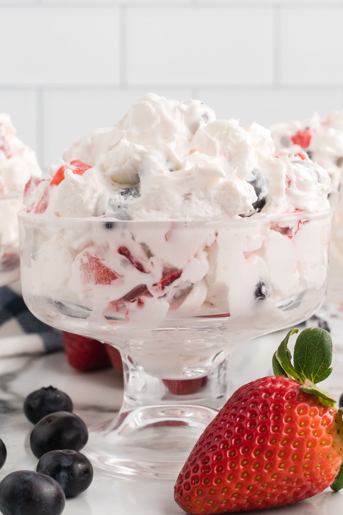 bowl of red white and blue cheesecake salad in a clear bowl