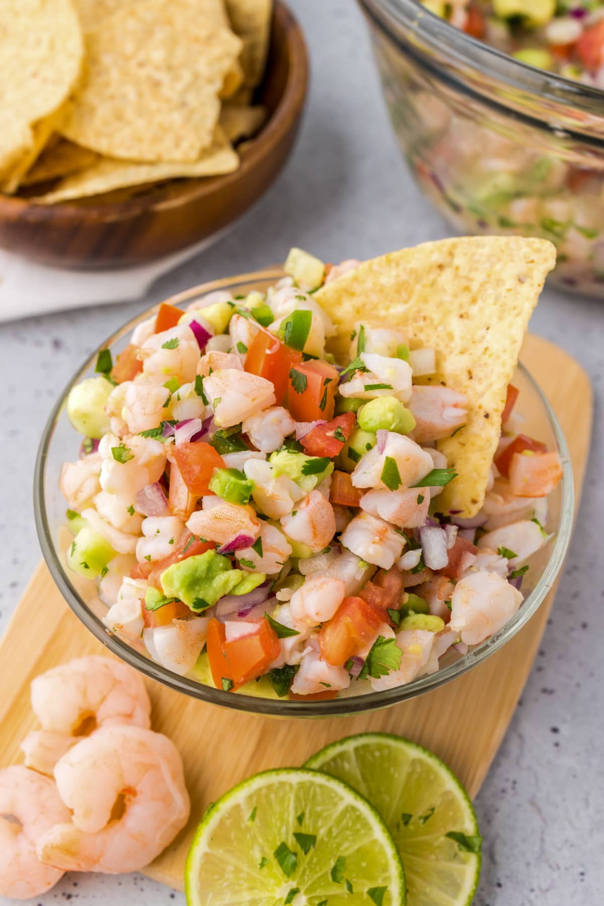 shrimp ceviche served in glass bowl with tortilla chips and lime