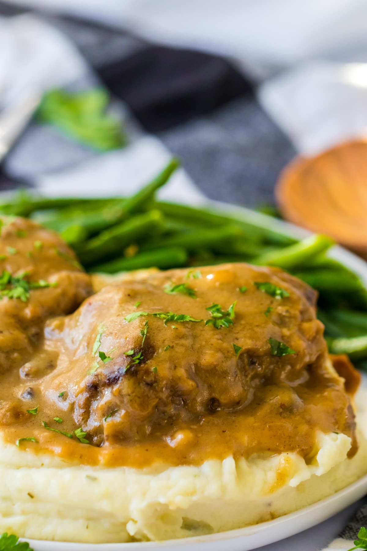 salisbury steak served over mashed potatoes with green beans