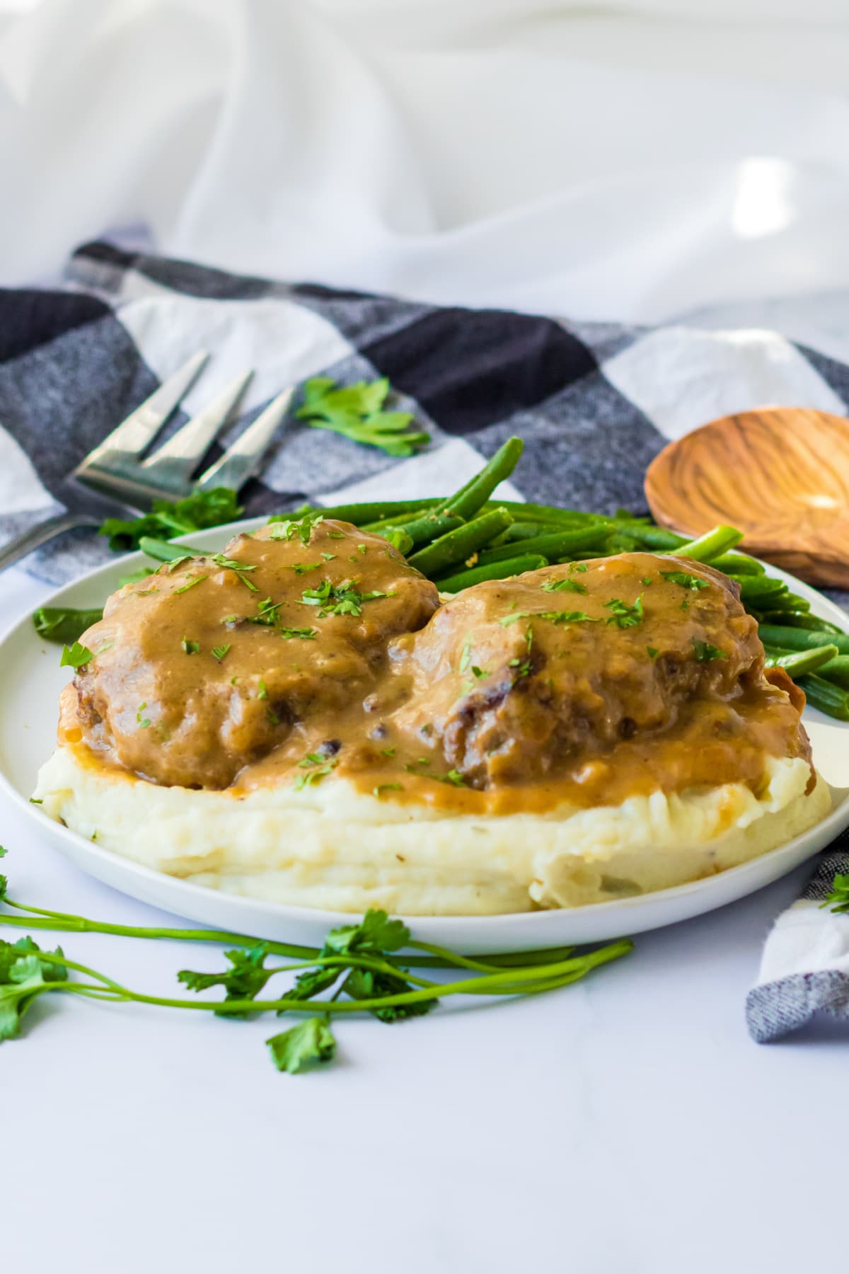 salisbury steak served over mashed potatoes with green beans