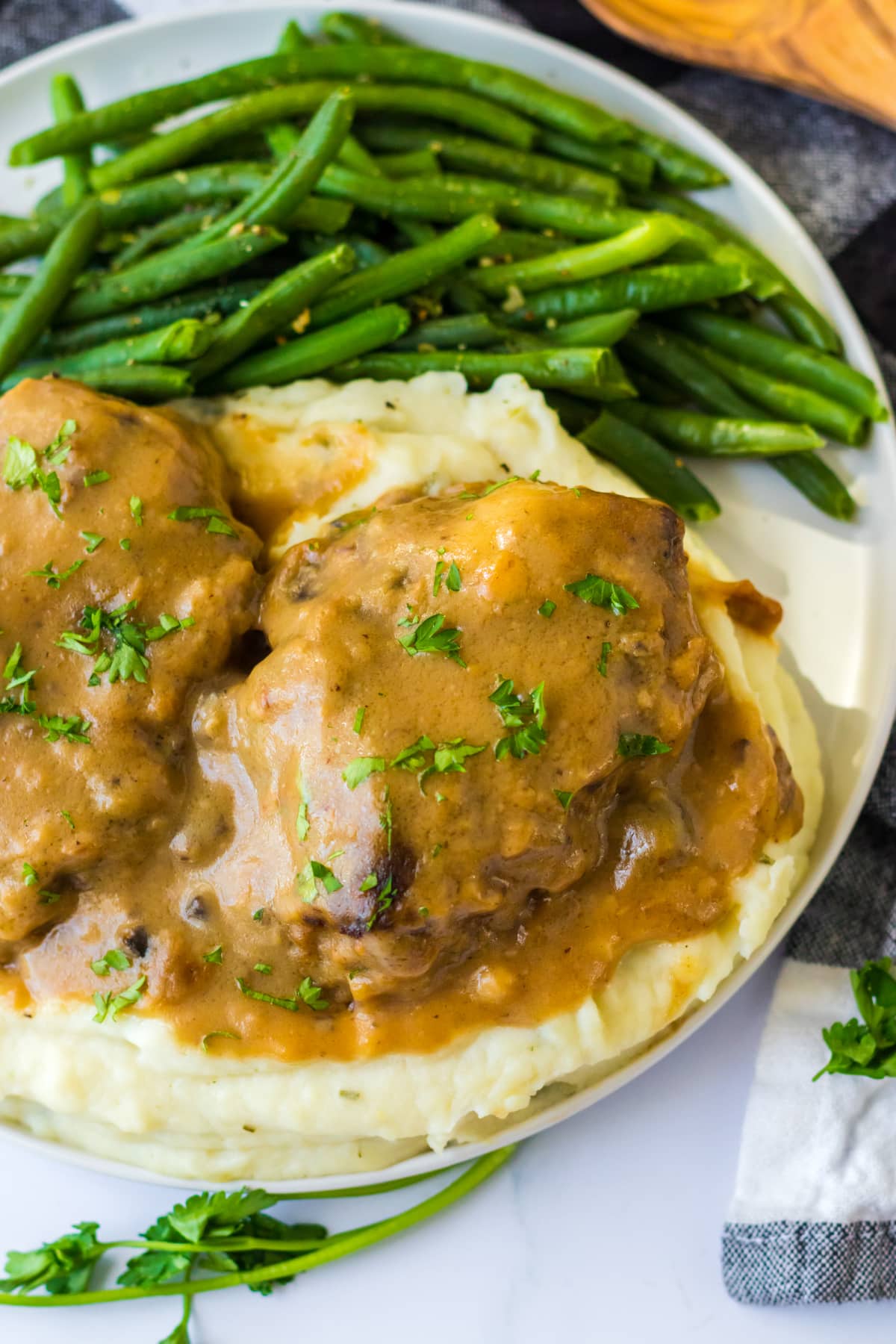 salisbury steak with parsley served over mashed potatoes with green beans