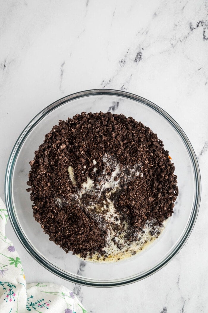 Oreo crumbs and butter in a bowl