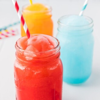 red, blue and orange slushie in glass mason jar with straws