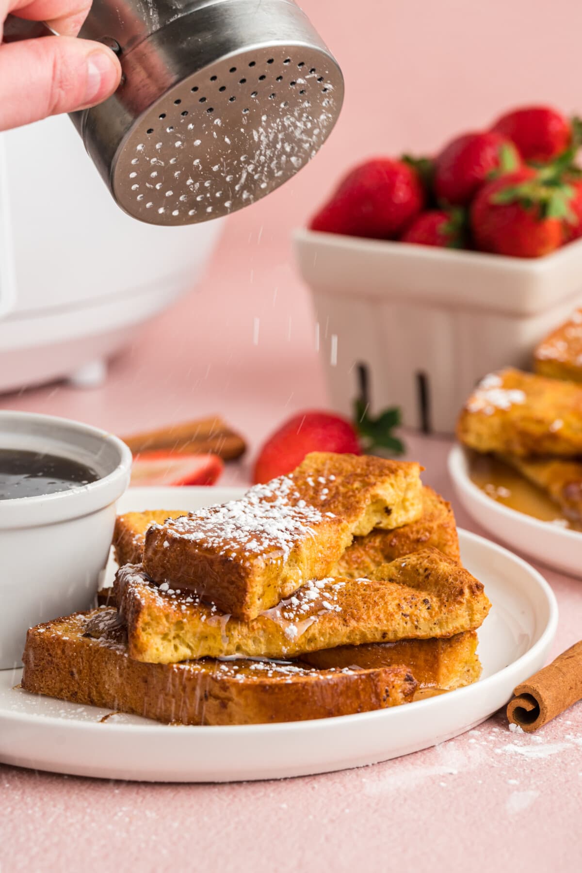 dusting powdered sugar over french toast sticks