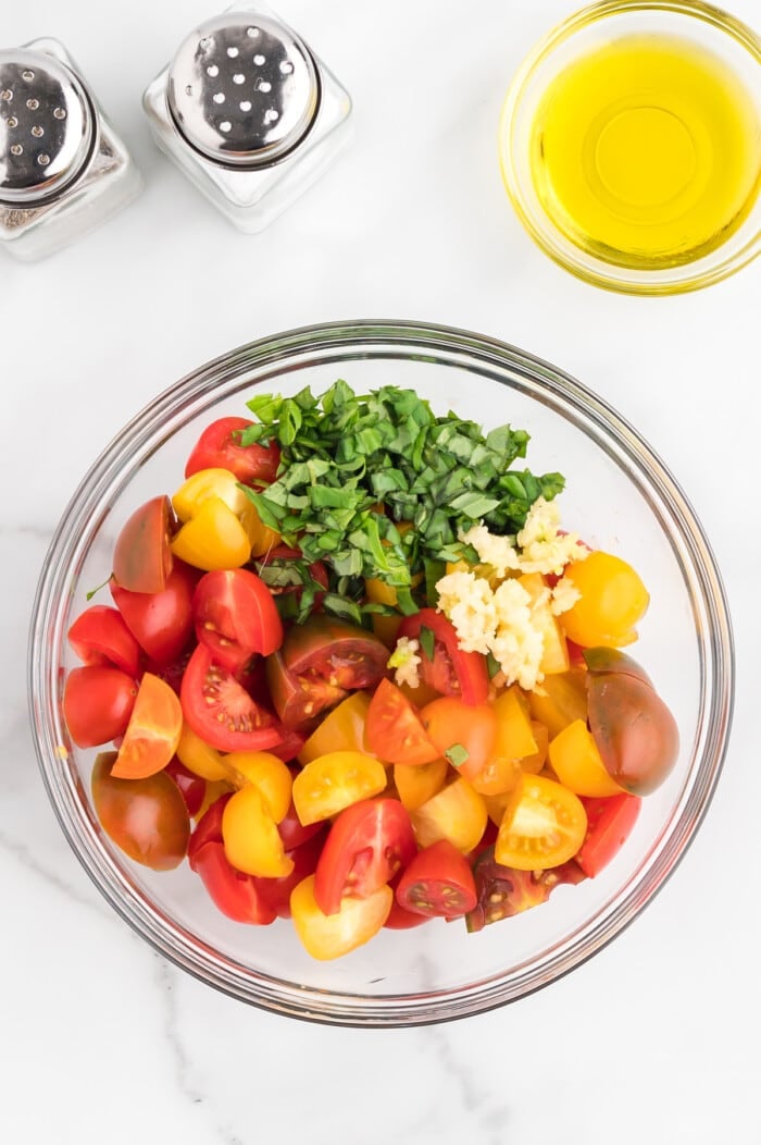 tomatoes, basil and garlic in glass bowl