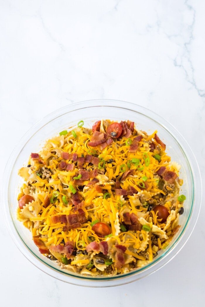 bacon on top of cowboy pasta salad in glass bowl