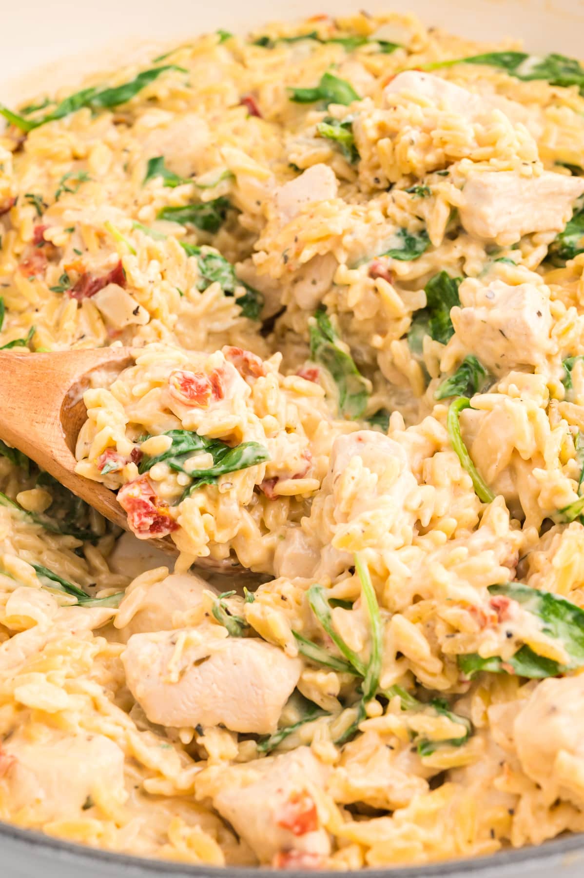 wooden spoon serving chicken orzo