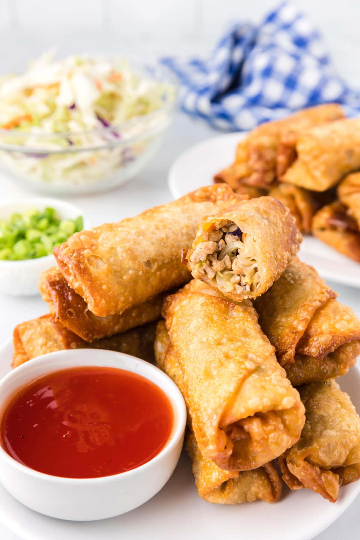 egg rolls on white plate with dipping sauce