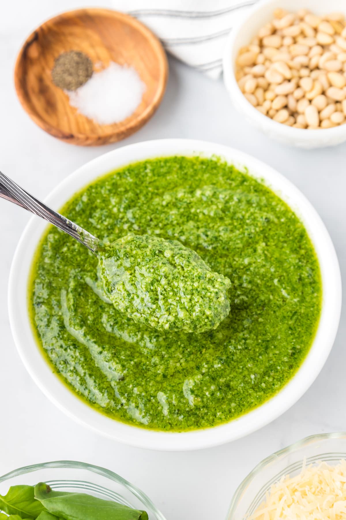 A spoon in a bowl of pesto