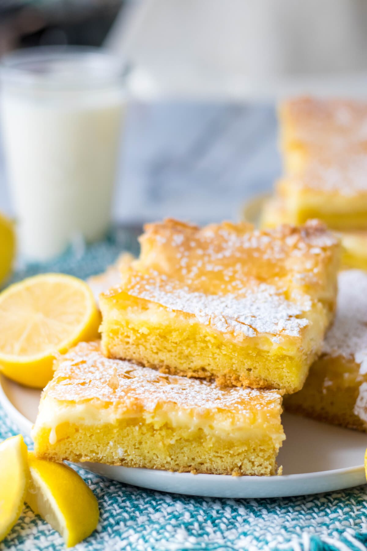 lemon gooey butter cake on a white plate with blue table