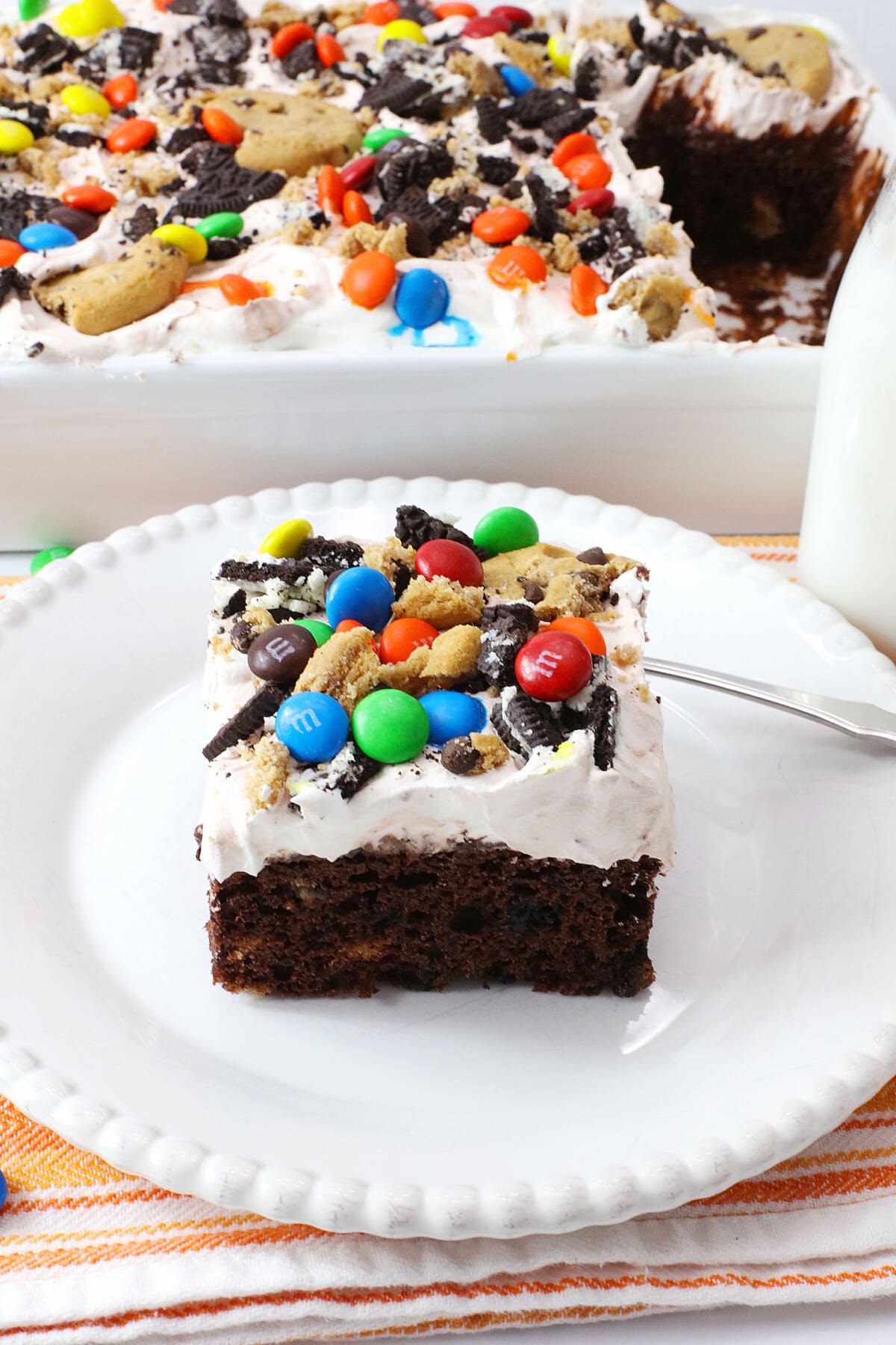 Monster Cookie Poke Cake on a white plate
