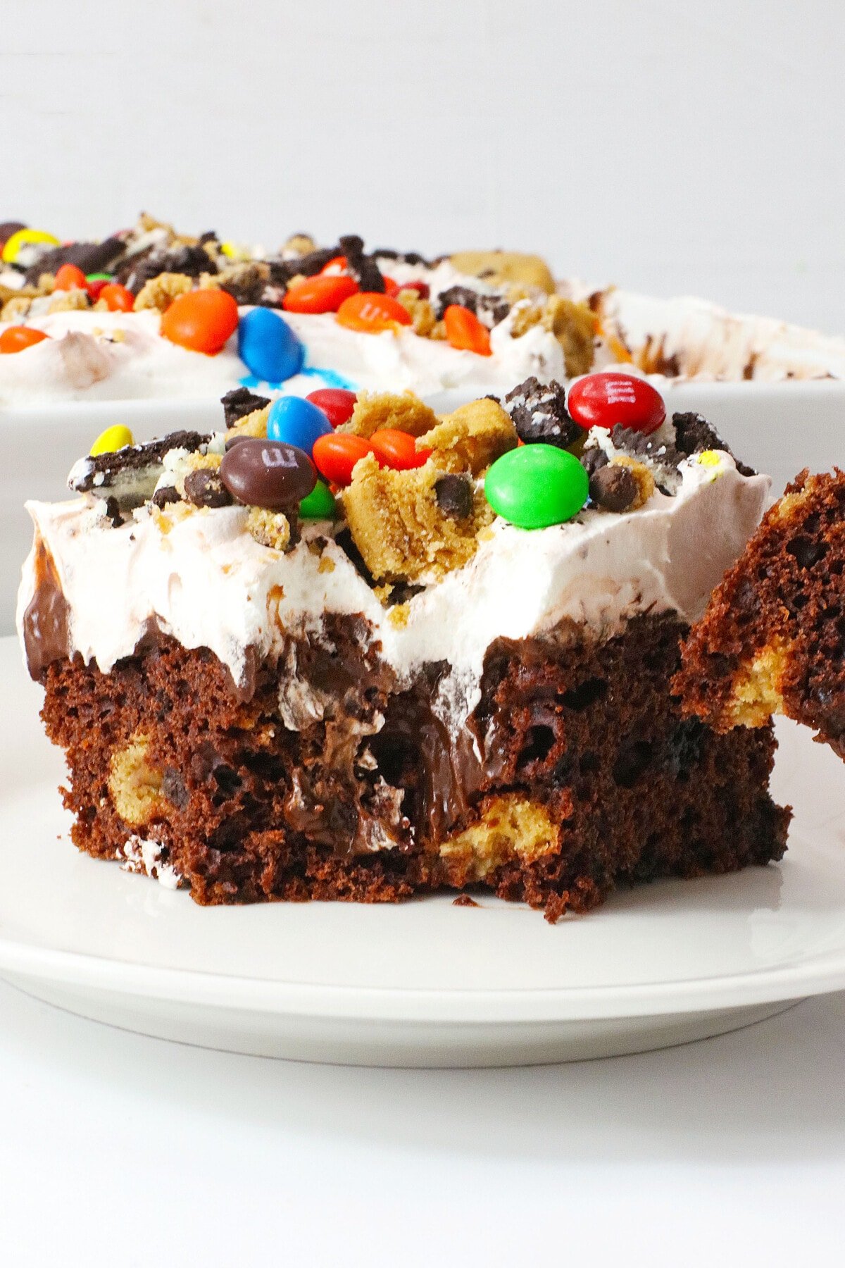 Monster Cookie Poke Cake on a white plate