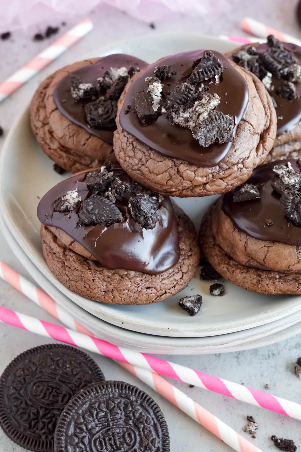 white plate with oreo stuffed cookies and pink straws