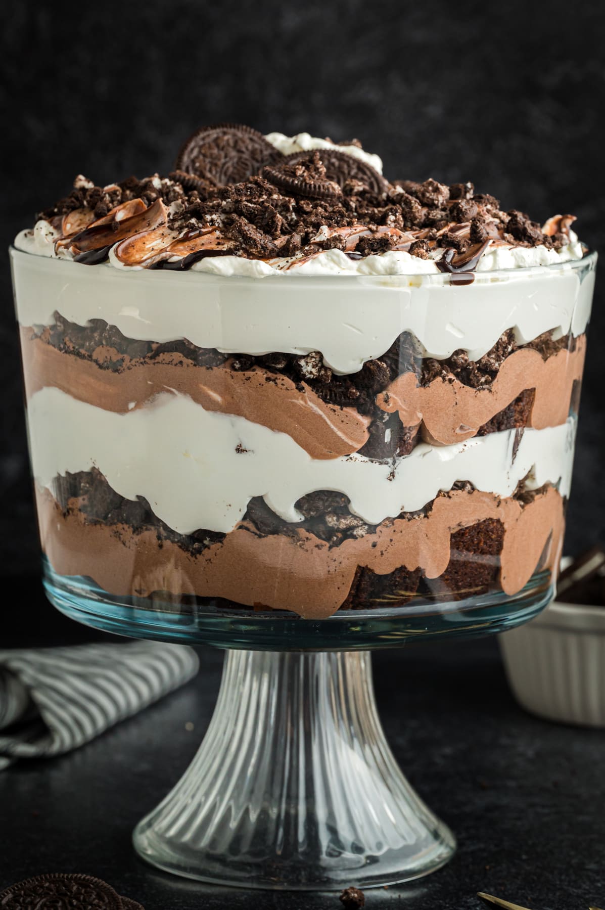 oreo trifle in glass dish with brownies, pudding and whip cream