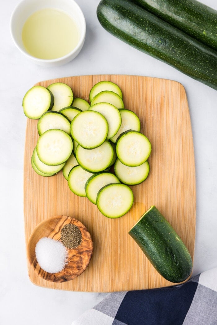 zucchini sliced on cutting board with salt and pepper