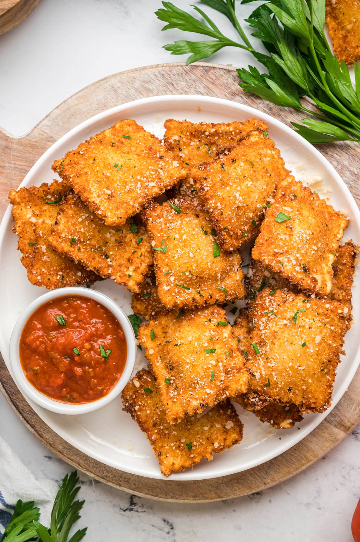 A plate of toasted ravioli with a dish of marinara sauce