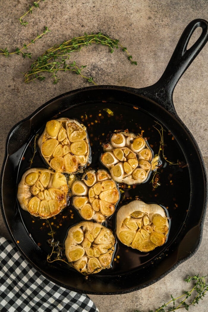 Roasted garlic bulbs in a cast iron skillet