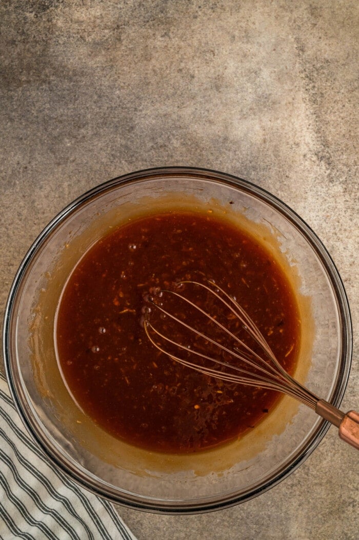 A whisk combining marinade ingredients
