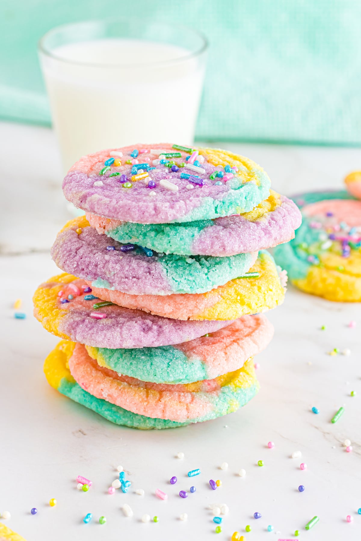 stack of unicorn cookies with glass of milk