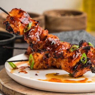 A chicken skewer upright on a plate