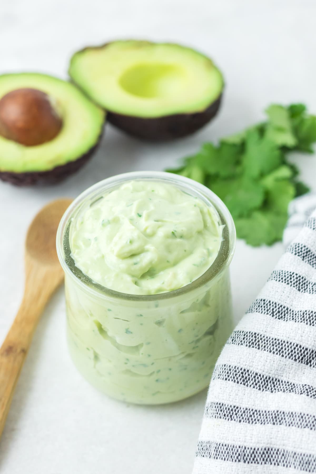 avocado crema in glass jar with wooden spoon to serve