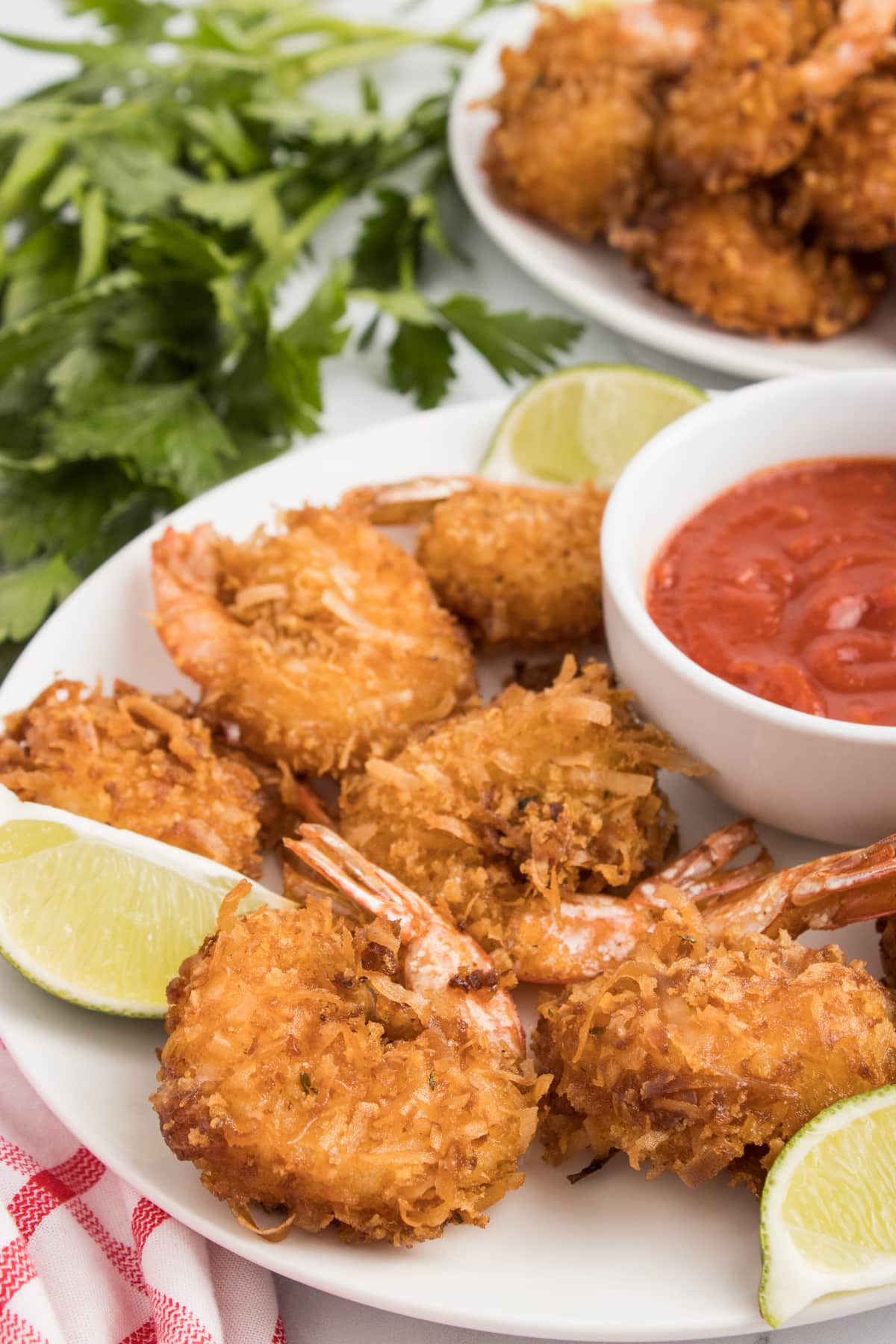 Angled overhead view of a plate of coconut shrimp with a bowl of sauce